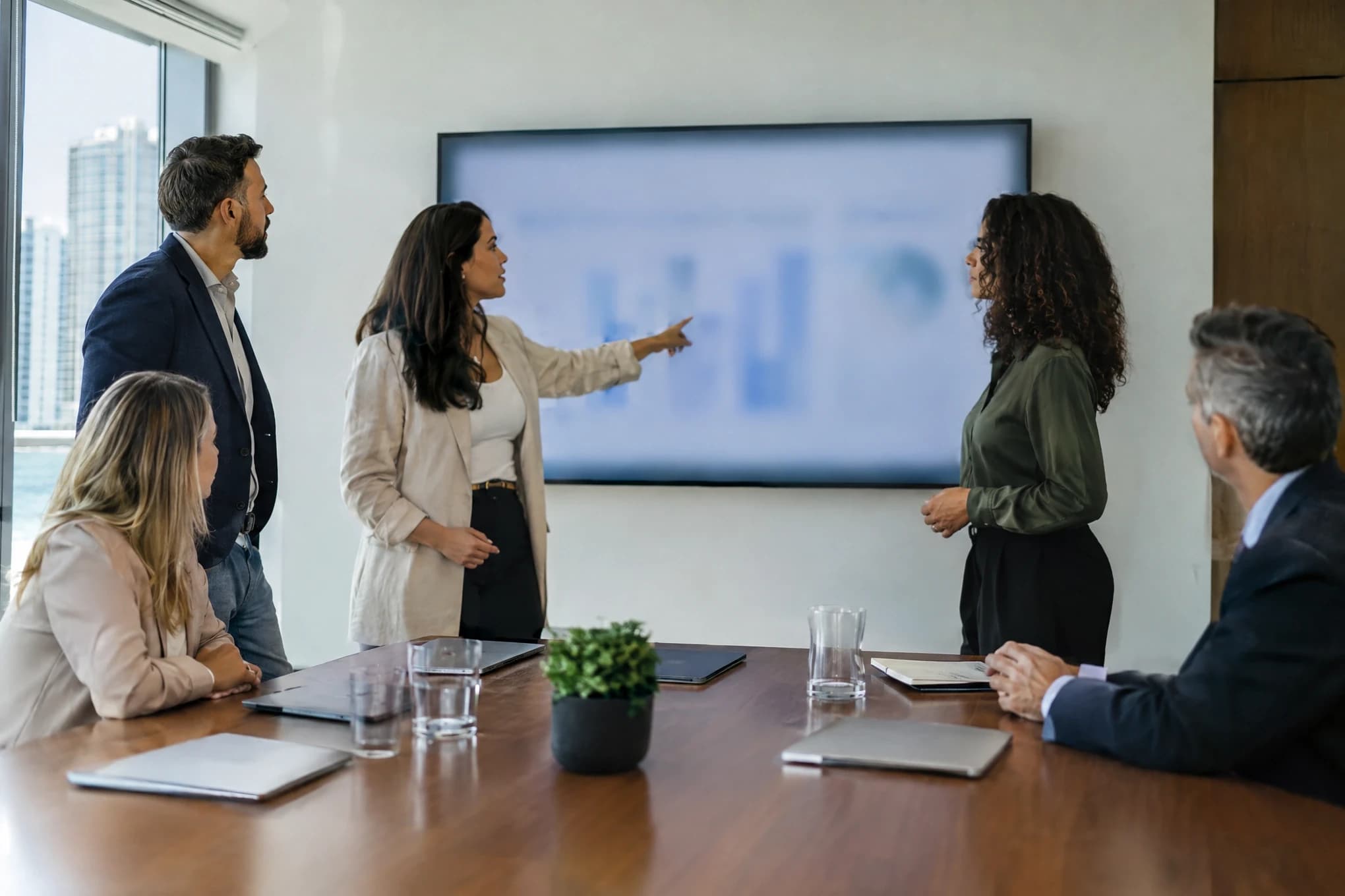 Un equipo de agencia de cuatro personas presenta una estrategia al equipo directivo de una empresa mediana