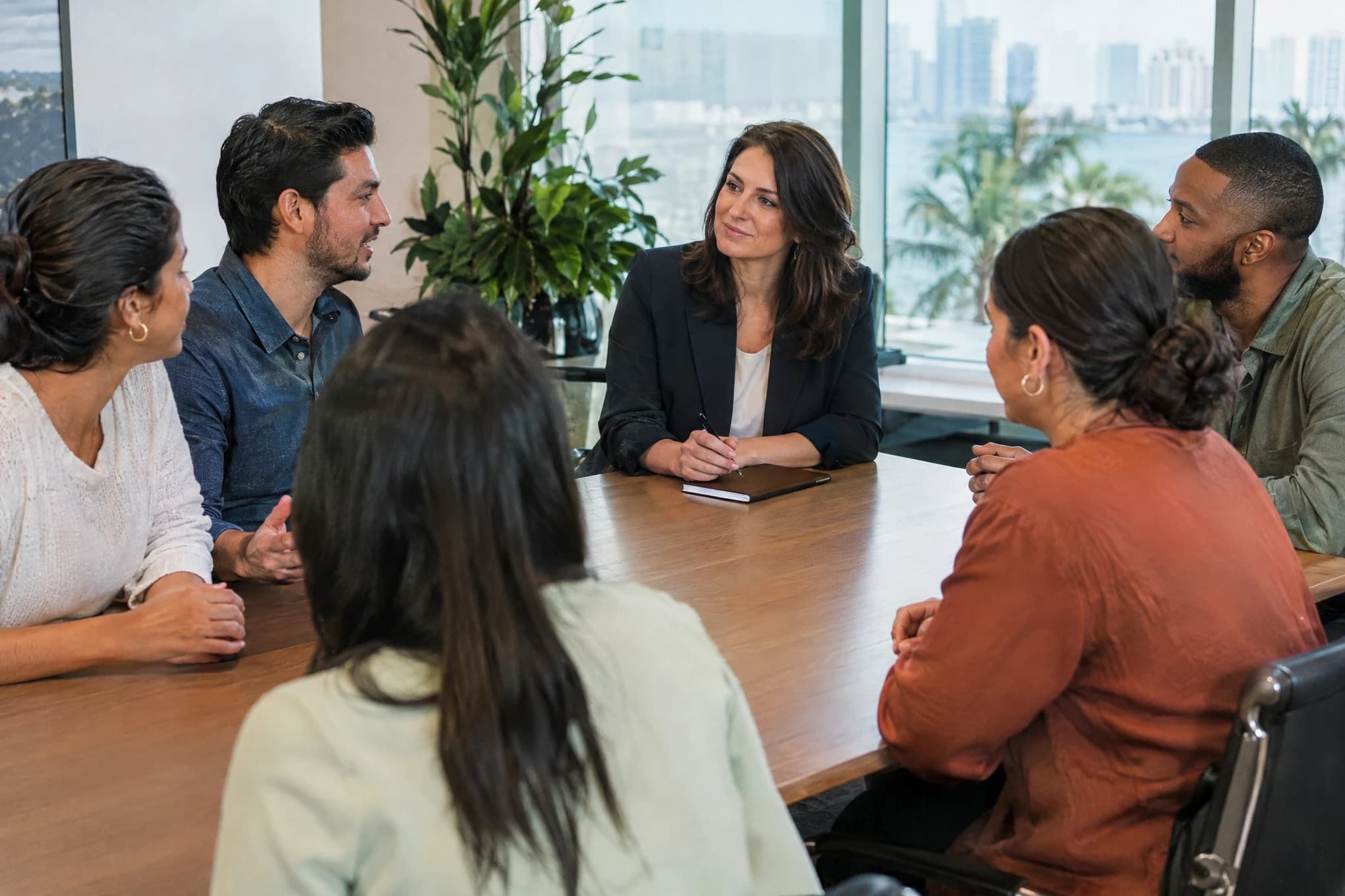 Una consultora de marketing escucha al equipo de seis personas de una empresa en su oficina