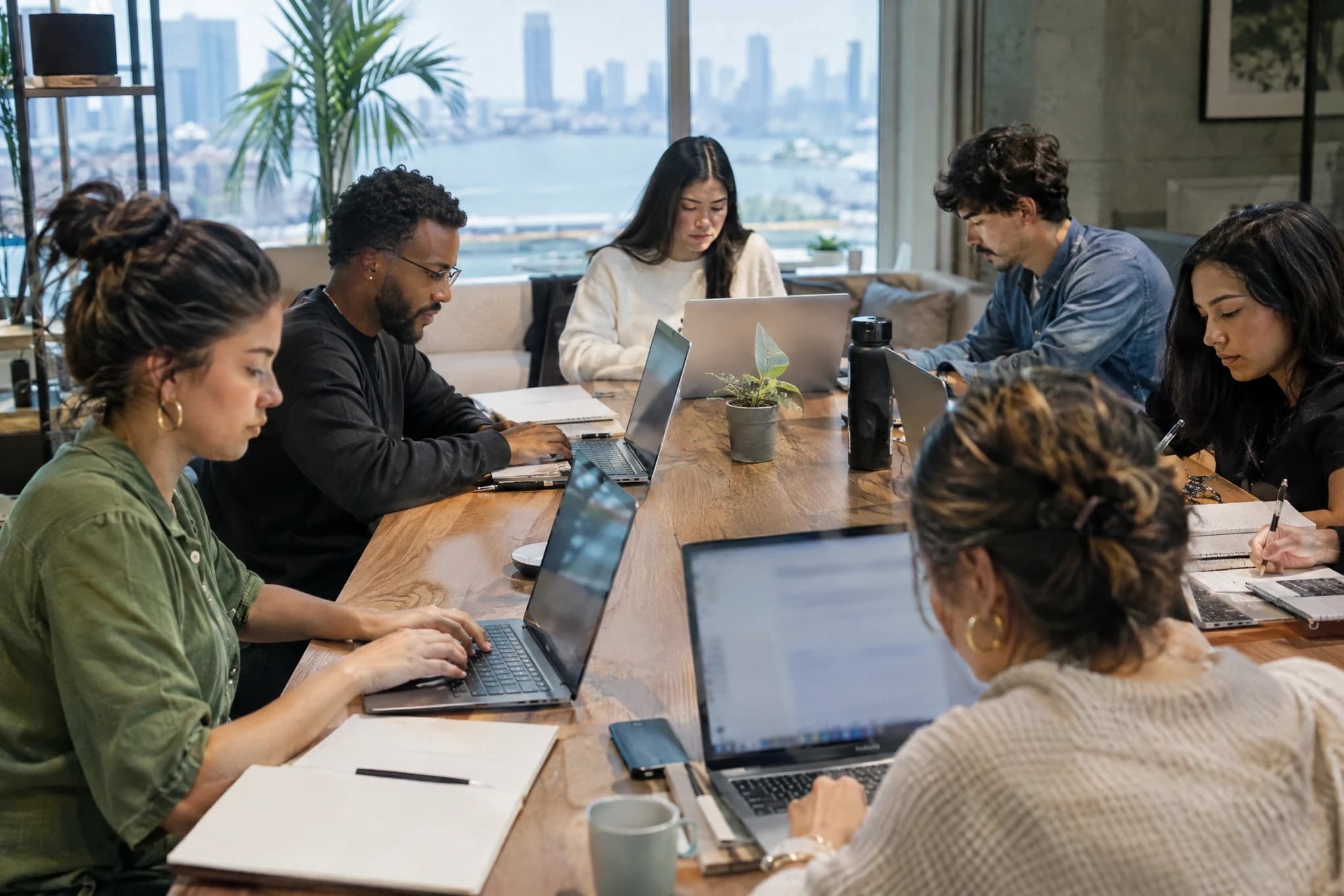 Un equipo de contenido y SEO de seis personas escribe y edita en una mesa compartida