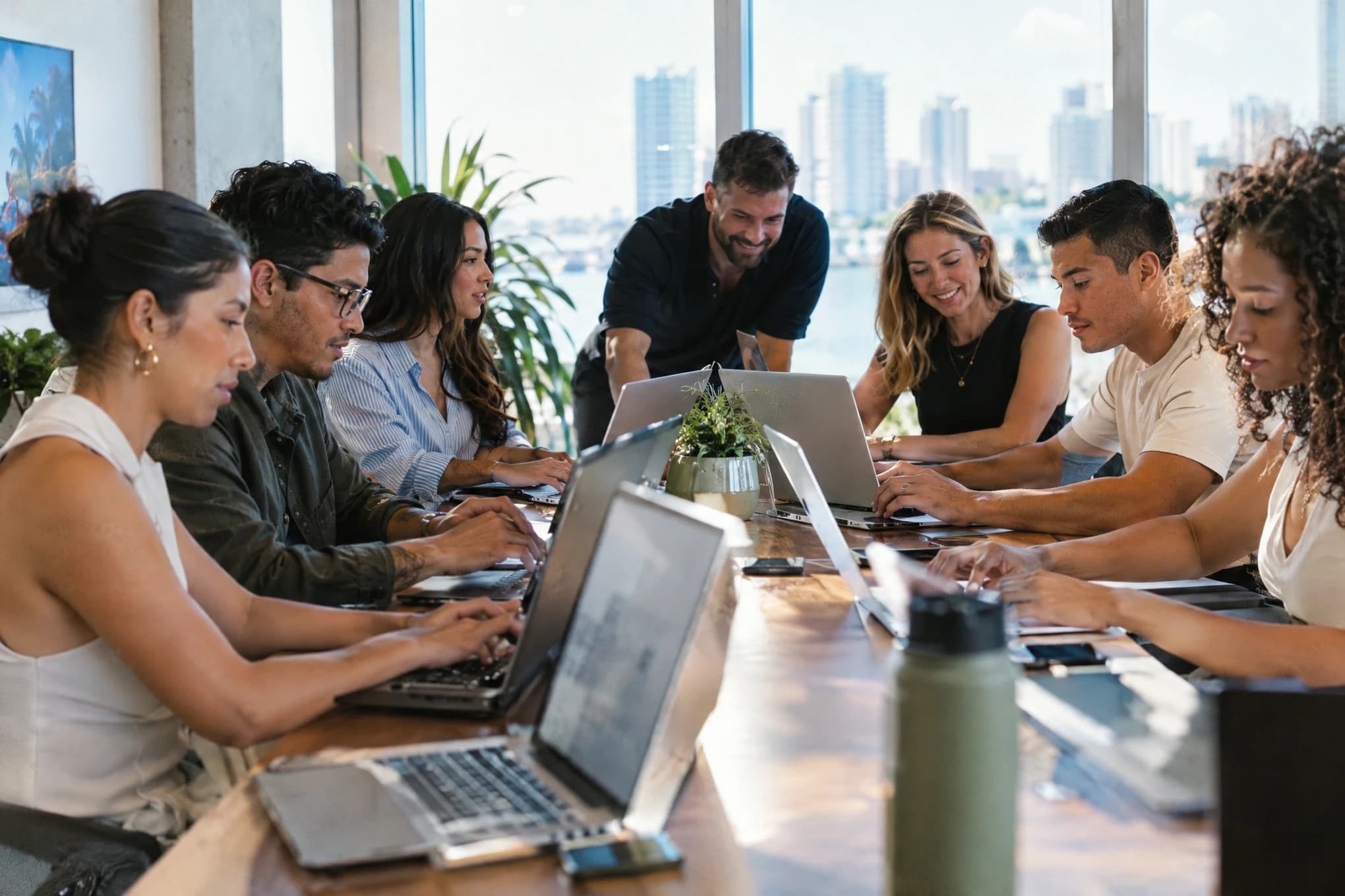 El equipo interno de marketing de una empresa y una agencia trabajan juntos en una mesa larga