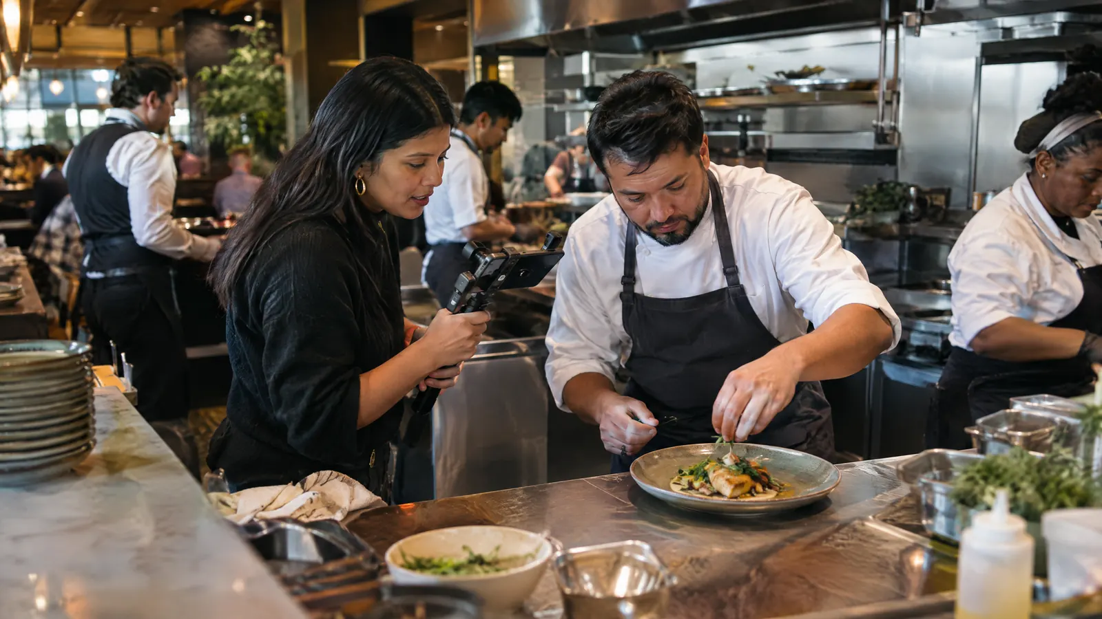 Una creadora de contenido grabando con el chef de un restaurante