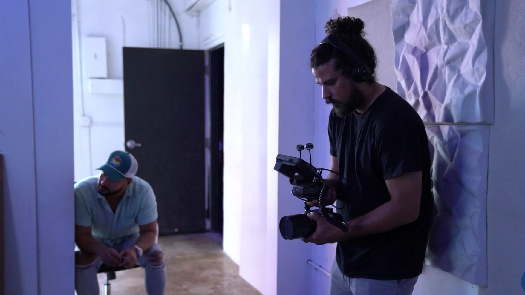 Un camarógrafo de Brito Marketing con la cámara al hombro en el set de oficina del comercial de Felicetti Law Firm.