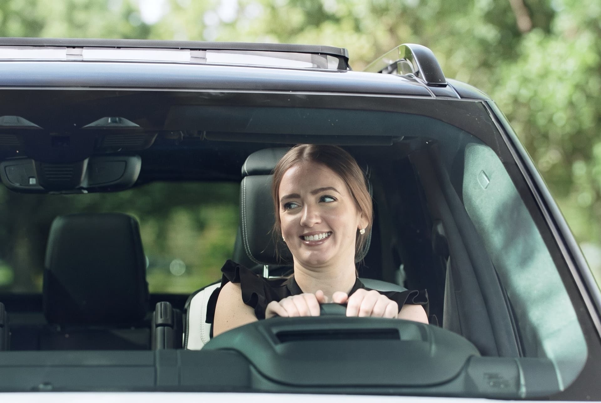A driver smiles at the wheel in the auto insurance commercial Brito Marketing made for GoldenTrust Insurance